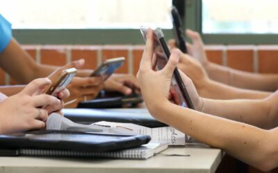 Uczniowie korzystają z telefonów w ławkach podczas lekcji