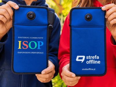 Uczniowie pokazują etui na telefon z logo szkoły ISOP i logo Strefa Offline